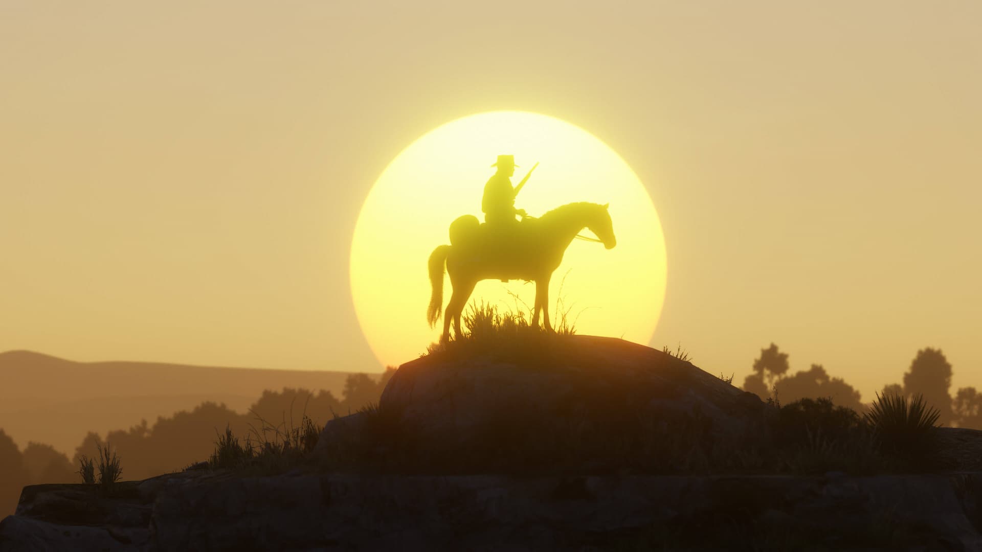 Horseback riders move along a fenced trail at sunset, surrounded by golden fields and distant trees.